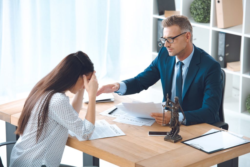 lawyer working with upset female client in office